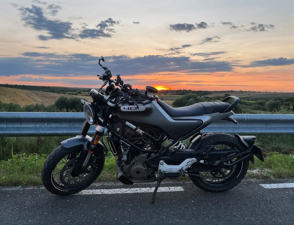 A black Husqvarna Svartpilen 401 on a road at sunset